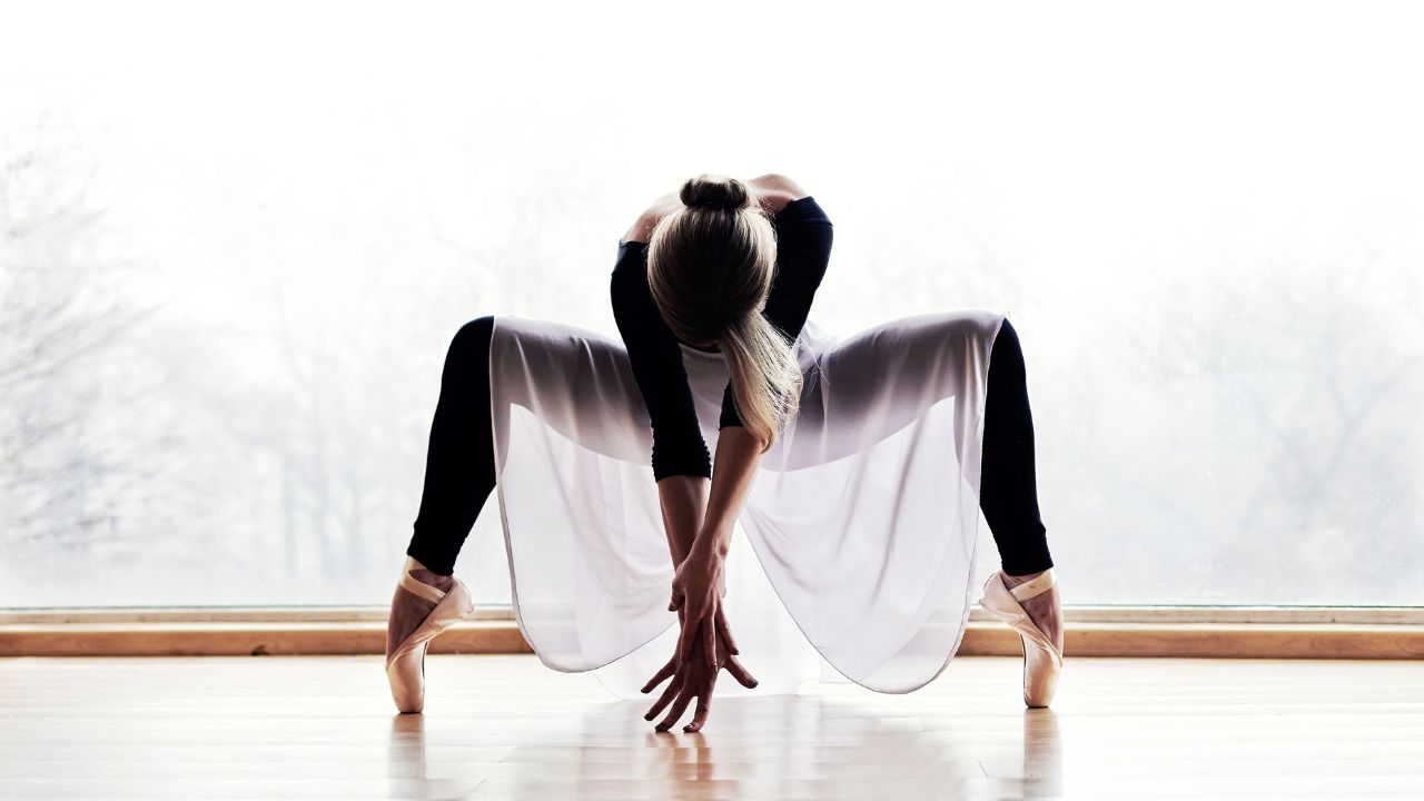 Shame and the dancer, dancer on pint, wearing parctice clothes head down hands in front touching the floor.