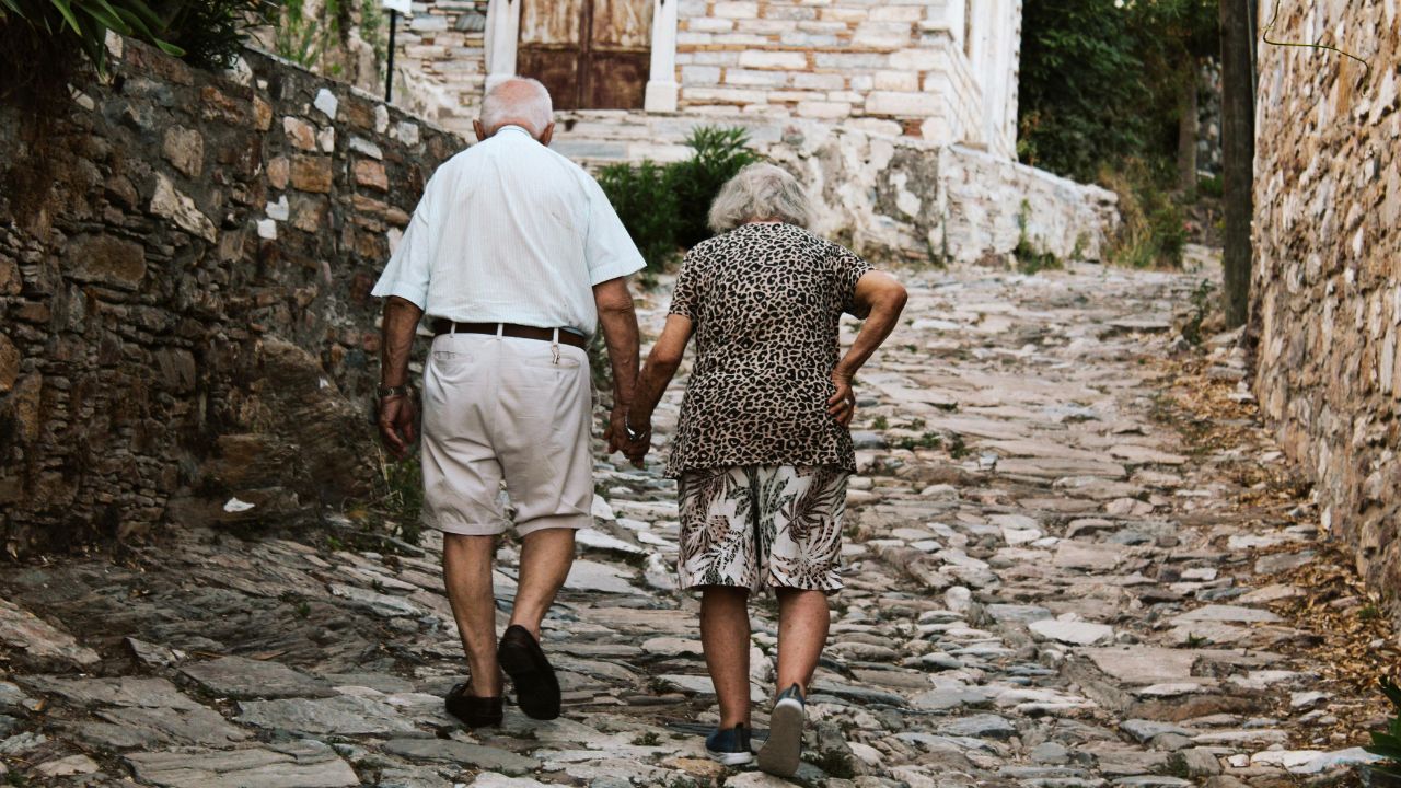 ) Aged parents walking hand in hand